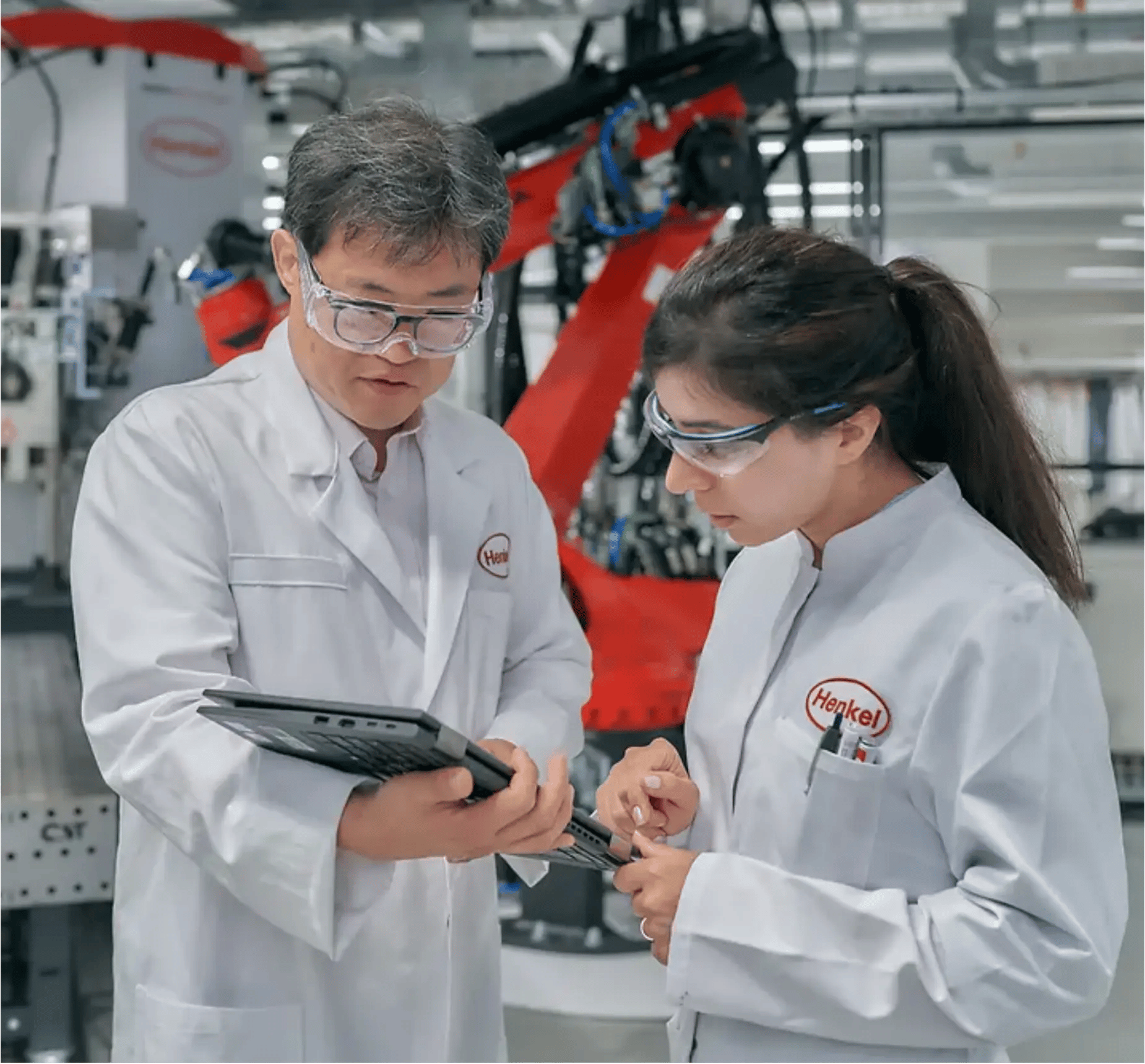 male and female henkel scientists looking at a computer in a lab